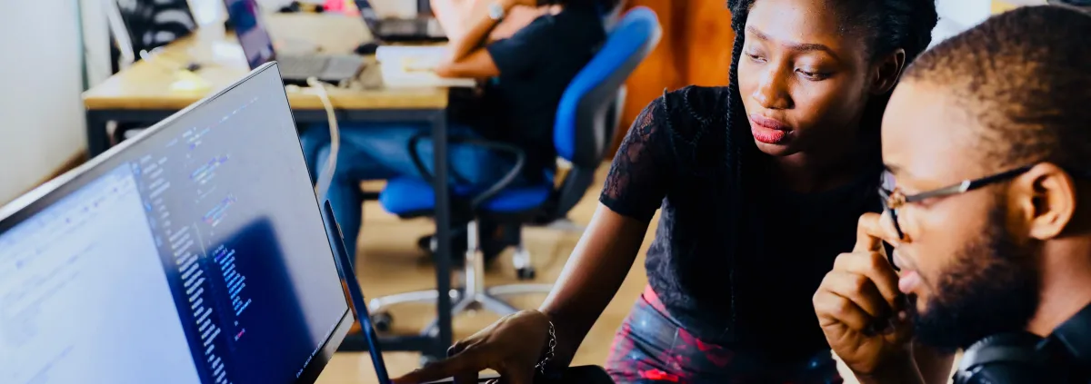 a group of people looking at a laptop