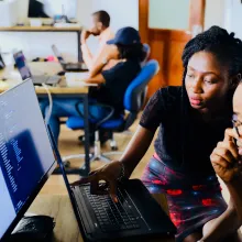 a group of people looking at a laptop